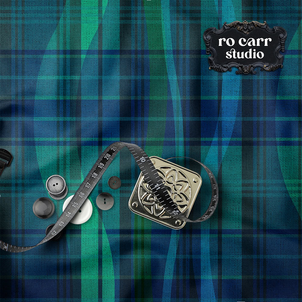 Flat lay of teal and blue plaid fabric with sewing notions: measuring tape, buttons, and an ornate square buckle.