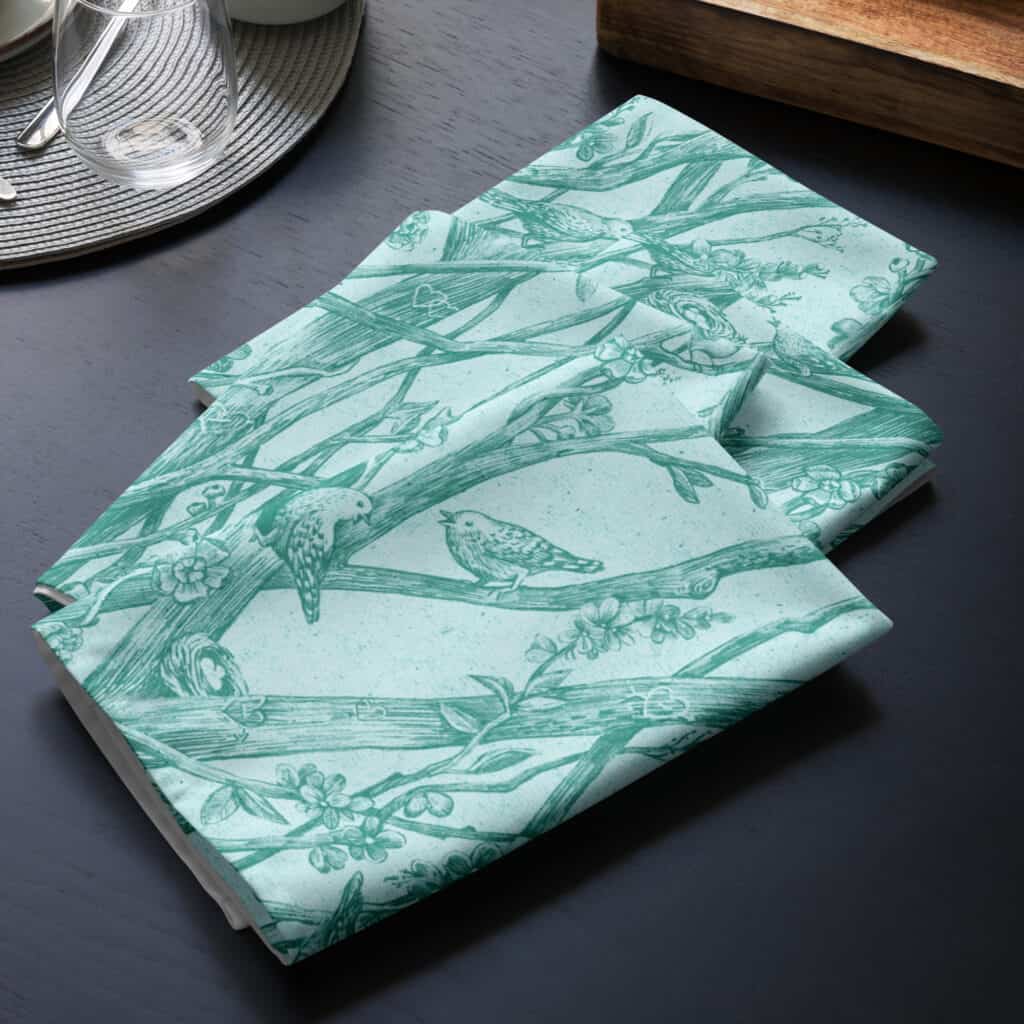 Folded stack, set of four cloth napkins, printed with Toile de Vie in aqua.