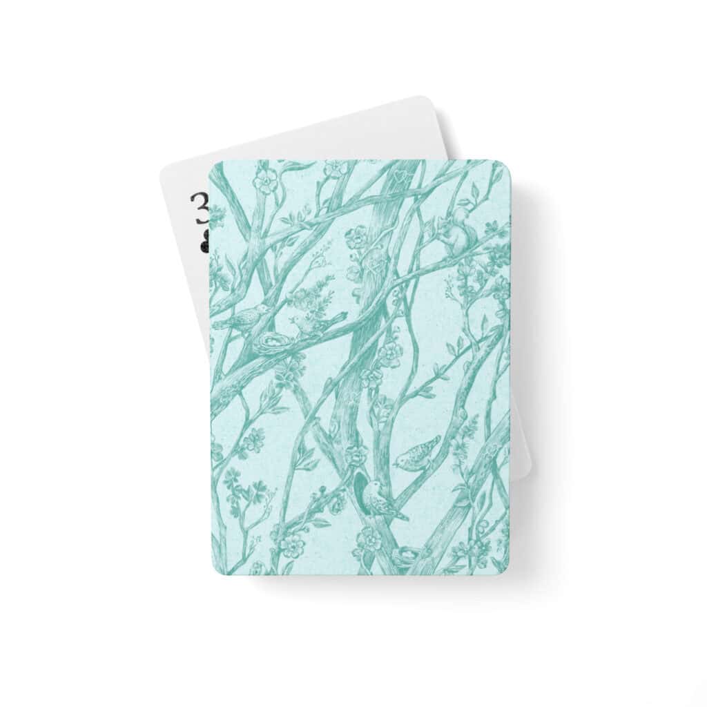 Set of playing cards shown printed with Toile de Vie pattern in aqua.