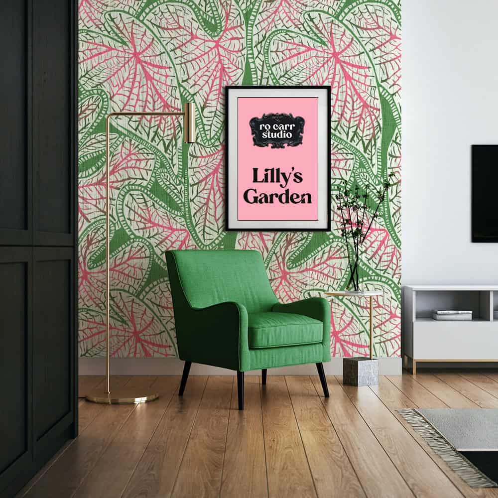 Caladium leaf wallpaper behind a green armchair, with a framed pink print reading "Lilly's Garden."