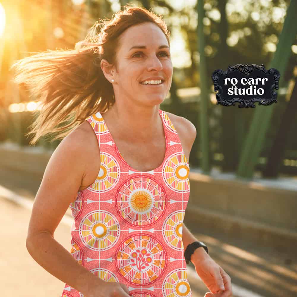 Woman jogging outside wearing a tank top printed with Tour de Citrus in warm pink grapefruit.