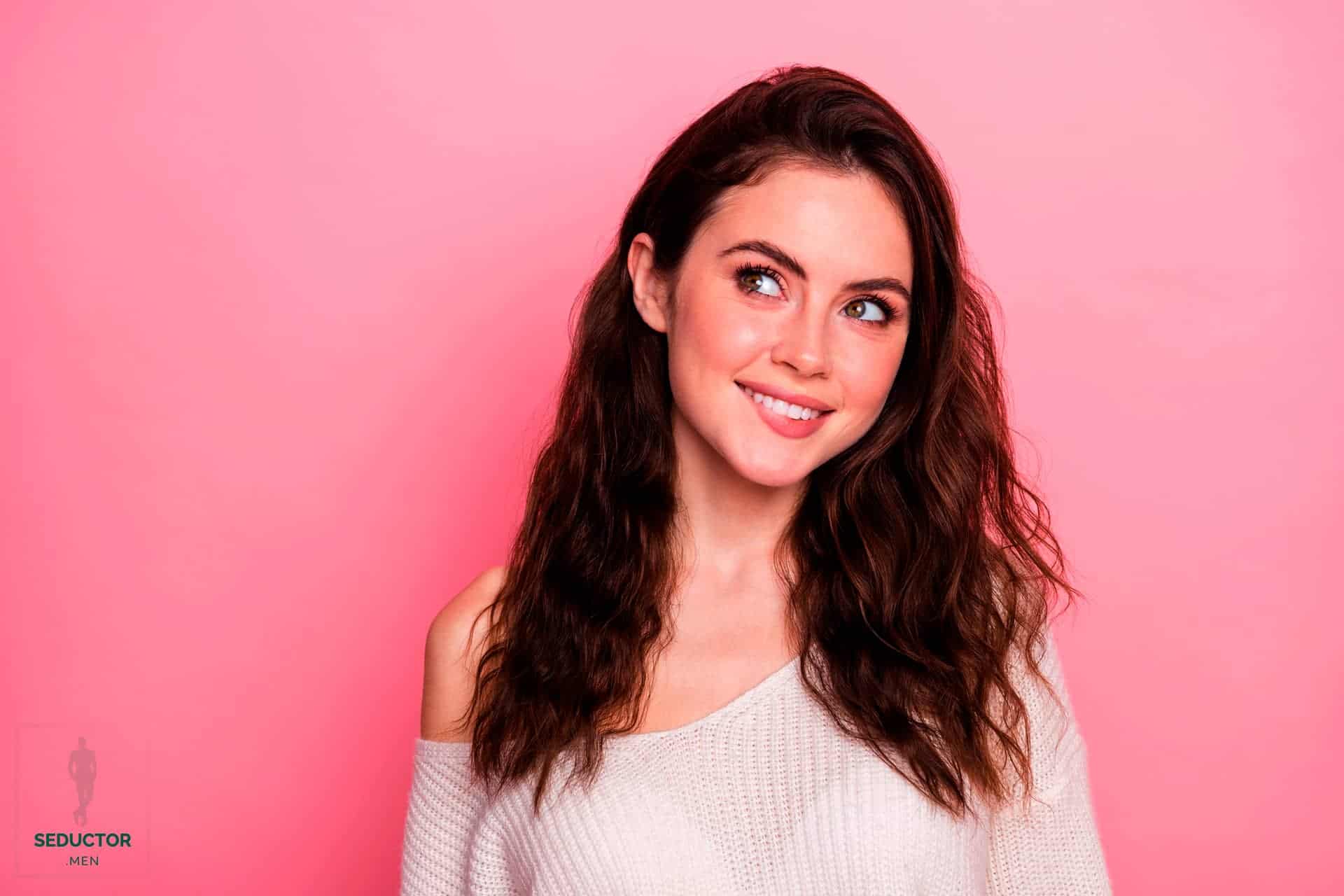 Imagen de una mujer atractiva sonriendo y mirando hacia un lado.