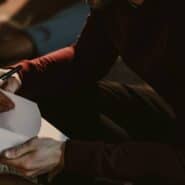 Hombre escribiendo en un cuaderno sus reglas de la seducción