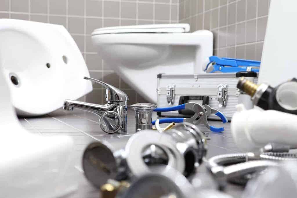 Plumbing tools and fixtures on a bathroom floor, ready for repair, reflect Service Champions’ trusted local expertise and care.