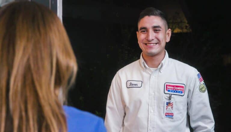 Steven, a friendly Service Champions technician in an Azusa uniform, warmly greets a customer, reflecting trusted local care.
