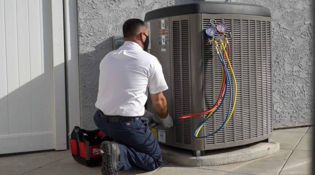 A friendly Service Champions technician in uniform expertly checks an AC unit in Rancho Santa Margarita, ensuring local home comfort.