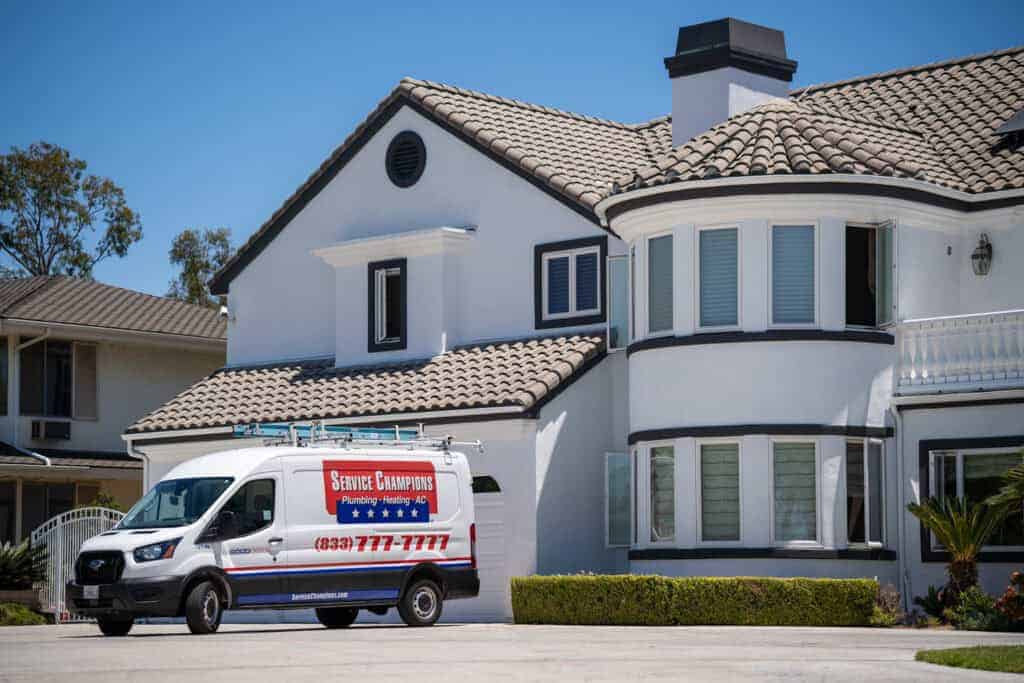A trusted Service Champions van stands ready outside a modern home, showcasing reliable local HVAC and plumbing care in SoCal.