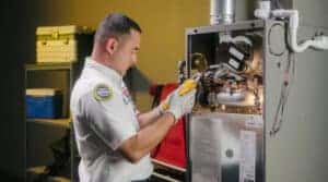 A friendly technician inspects furnace wiring, delivering trusted home comfort solutions for Southern California families.