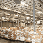 Large warehouse with stacks of printed direct mail pieces ready for distribution.