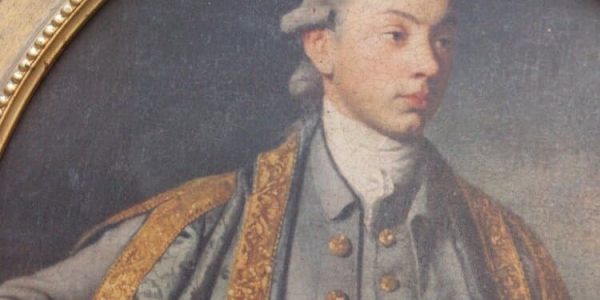 A portrait of a man in a gold frame.