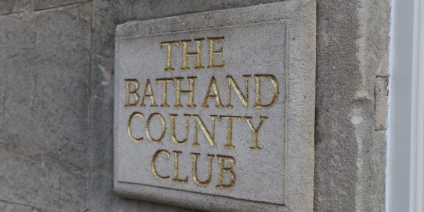 The bath and county club sign on a stone wall.
