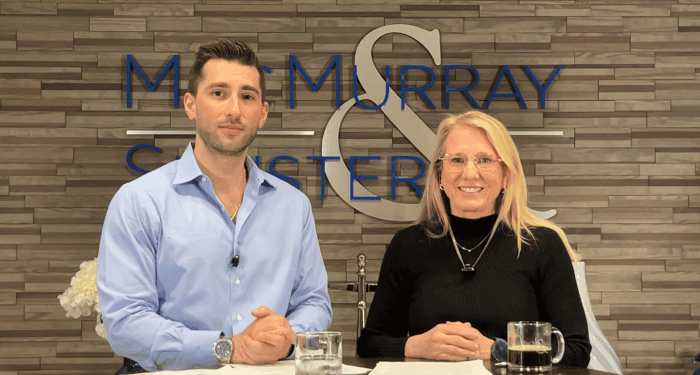 Two ComplianceTalk hosts seated at a desk in a law firm office recording a compliance discussion.