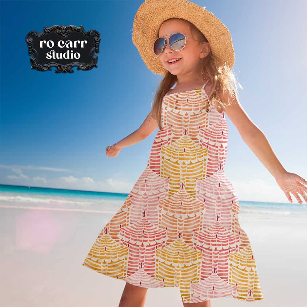 Young girl in a full-skirted Cabana Republic dress, spinning on a sunny beach.