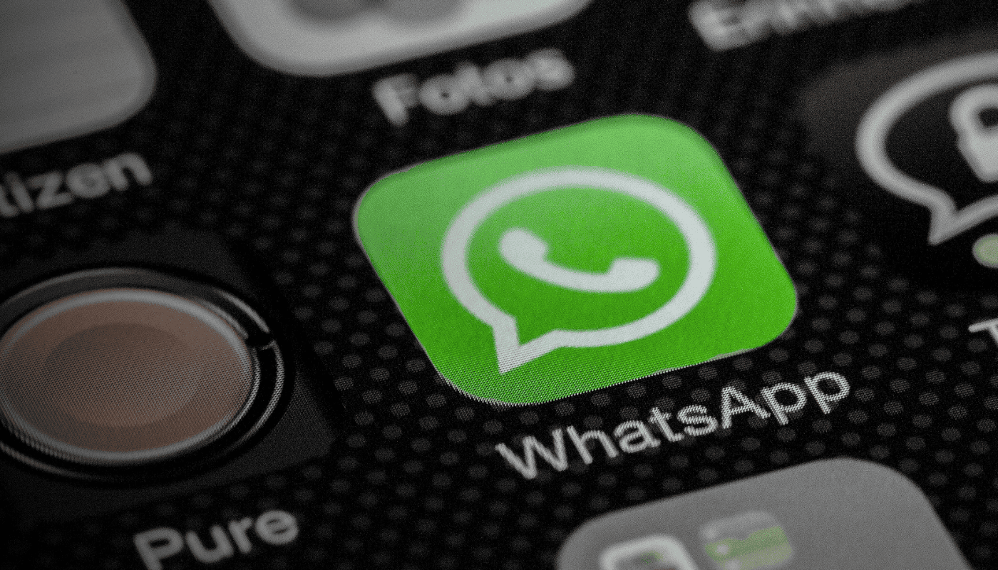 A smartphone displaying a WhatsApp icon, illustrating WhatsApp's move into paid subscription tiers and the impact for businesses and founders relying on the platform for daily customer communication.