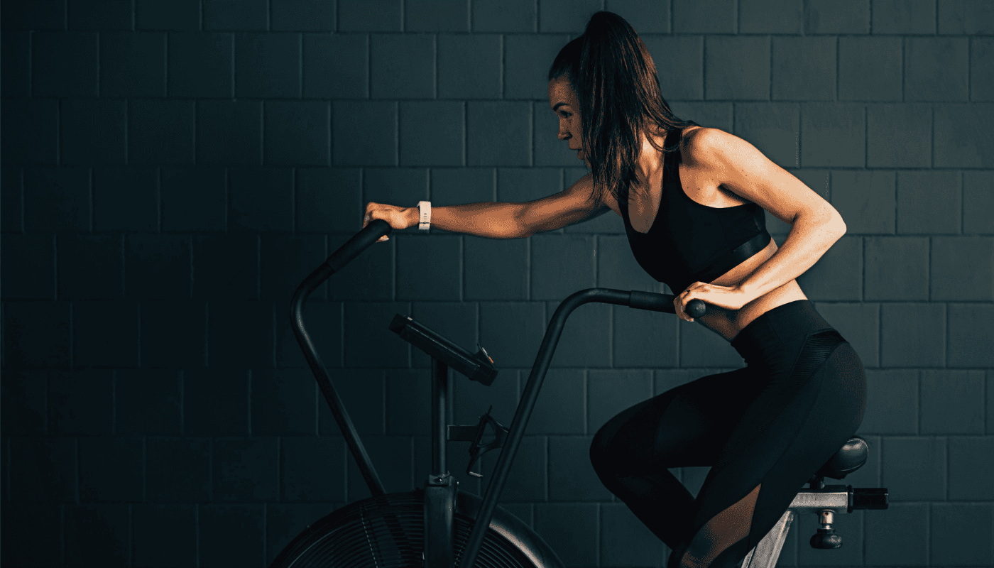 A on a bike, illustrating Spotify's expansion into fitness content through its new Peloton partnership, giving Premium subscribers access to over 1,400 ad-free workout classes.