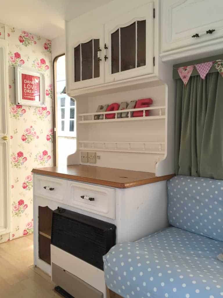 Looking towards the doorway of Dolly the caravan! I painted the cupboard area in fresh white and wallpapered the walls as part of my caravan makeover. More info on both of my caravan makeovers on the blog!