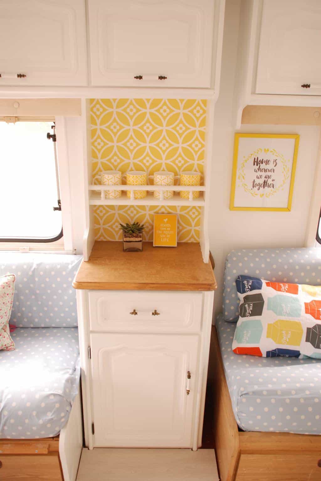 Caravan Renovation Project: After we'd carried out our restoration. Dolly looks fresh and bright with yellow wallpaper and white cabinetry in the lounge area.