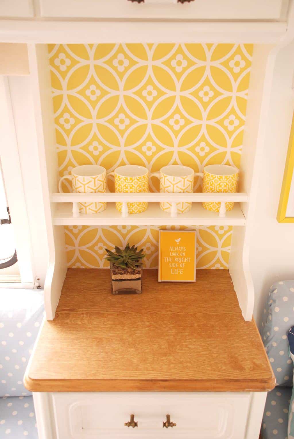 Caravan Renovation Project: After we'd carried out our restoration. Dolly looks fresh and bright with yellow wallpaper and white cabinetry.