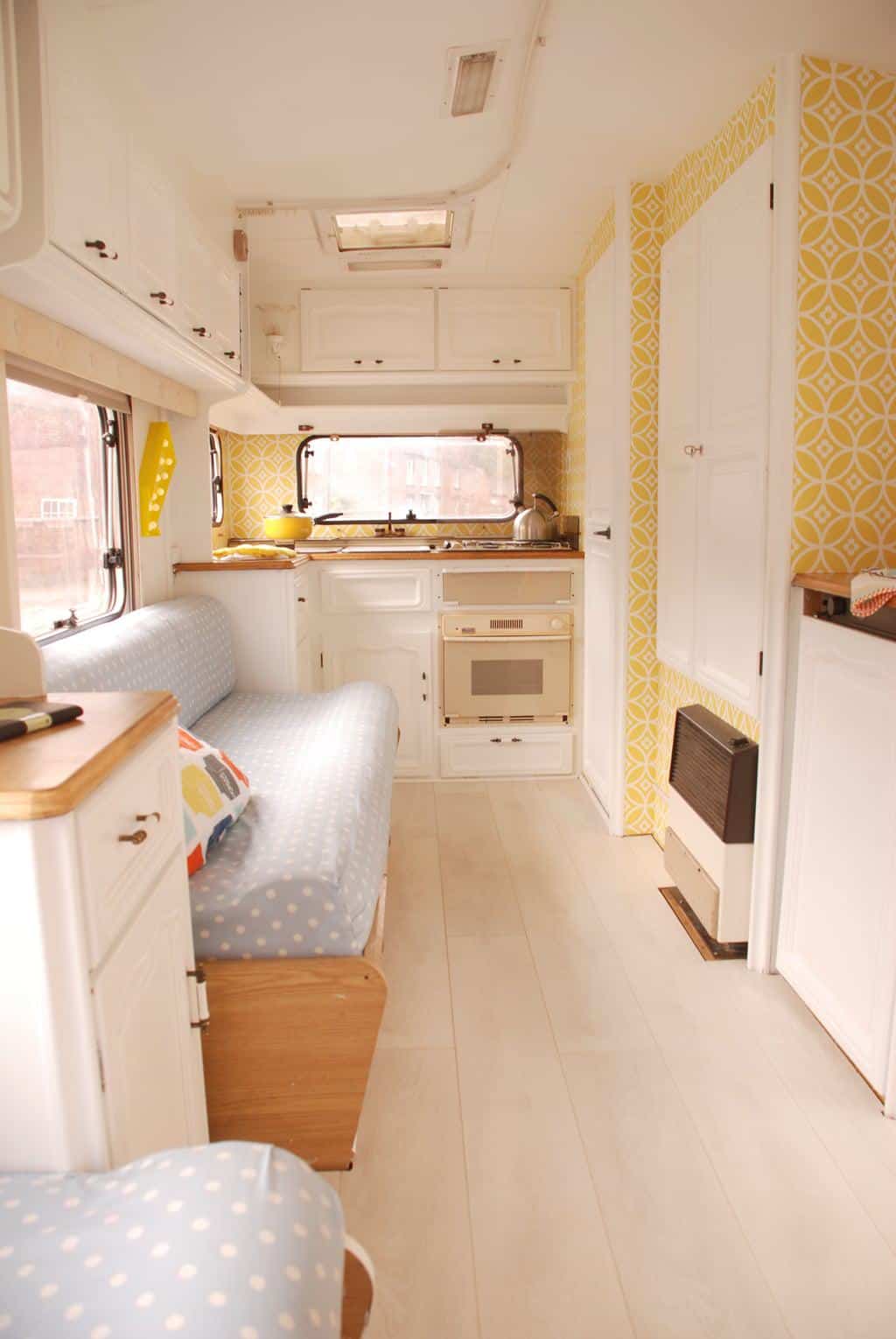 Caravan Renovation Project: After we'd carried out our restoration. Dolly looks fresh and bright with yellow wallpaper and white cabinetry.