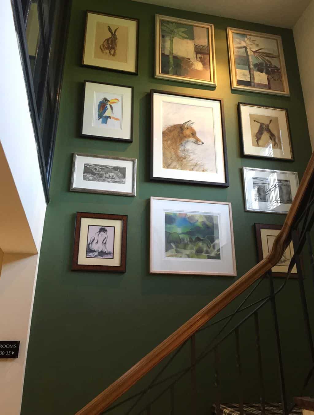 Fabulous gallery wall up the stairs at the Hare & Hounds, Tetbury