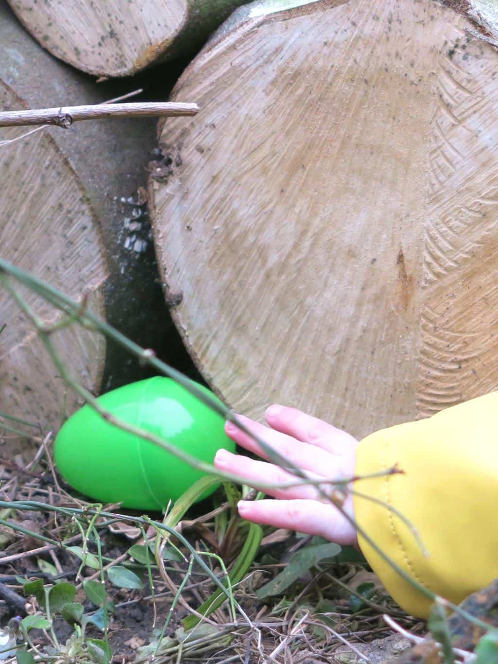 A little hand reaching for a colourful egg at an Easter egg hunt