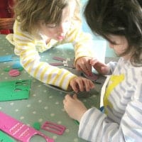 Twins making Easter bonnets at the kitchen table