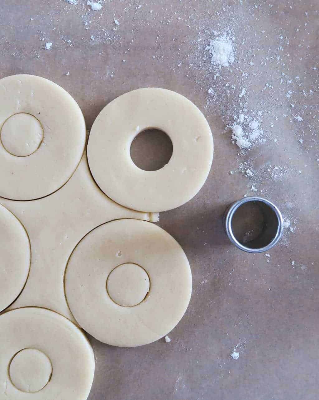Shortbread cookie dough, cut into rounds, waiting to be turned into edible flower biscuits