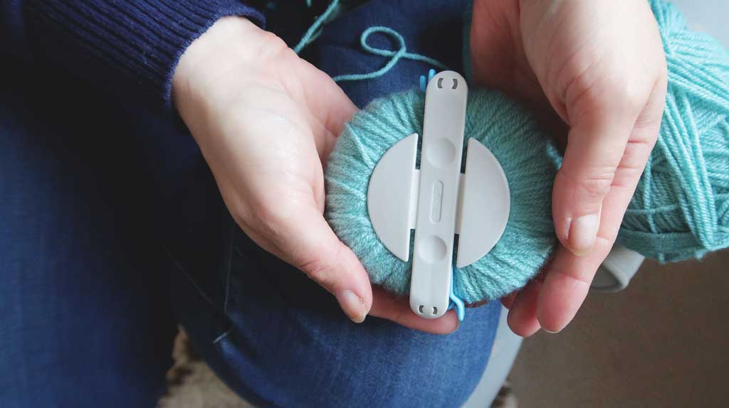 tutorial demonstrating how to make pom poms with a pom pom maker
