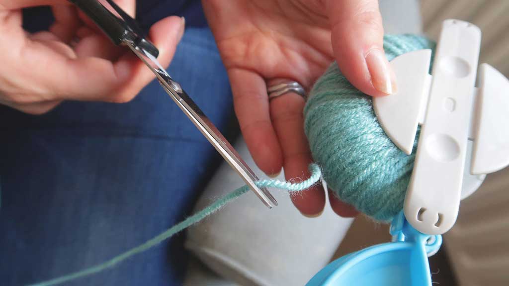 tutorial demonstrating how to make pom poms with a pom pom maker