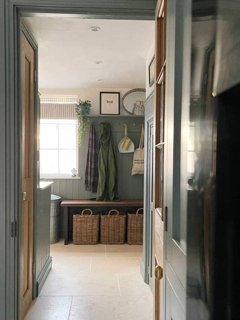Green painted tongue and groove woodwork in the boot room of The Listed Home — with Monte Carlo limestone floor from Quorn Stone