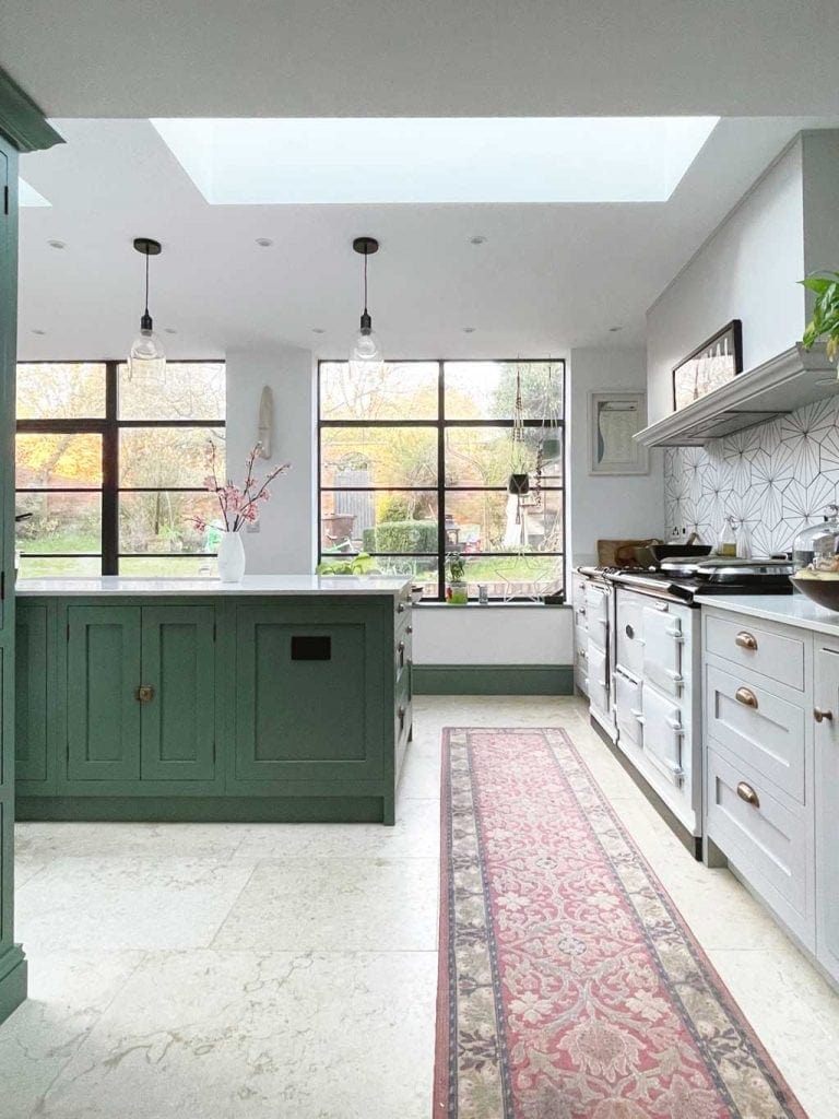 Green and grey shaker kitchen in The Listed Home — with Crittall windows and doors. And Monte Carlo limestone floor from Quorn Stone
