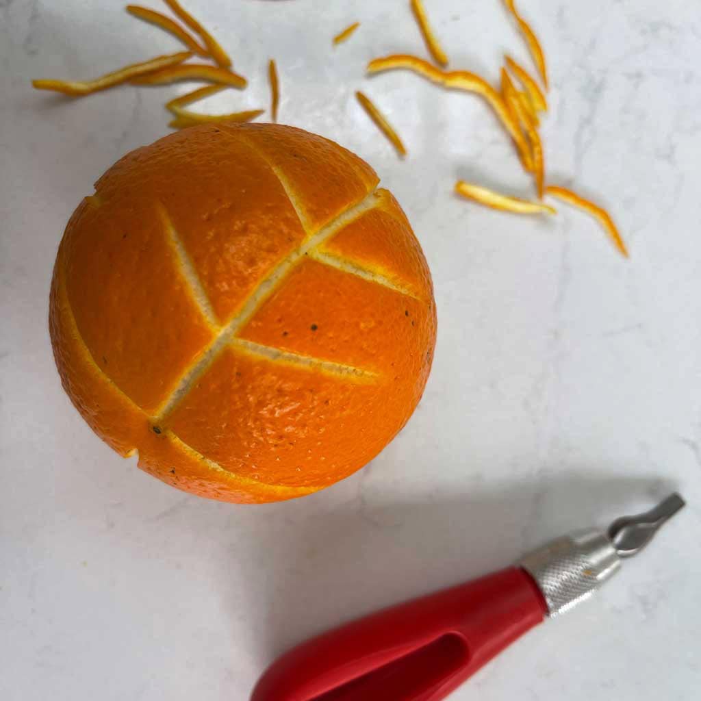 Lino cutting an orange to make clove and orange pomanders