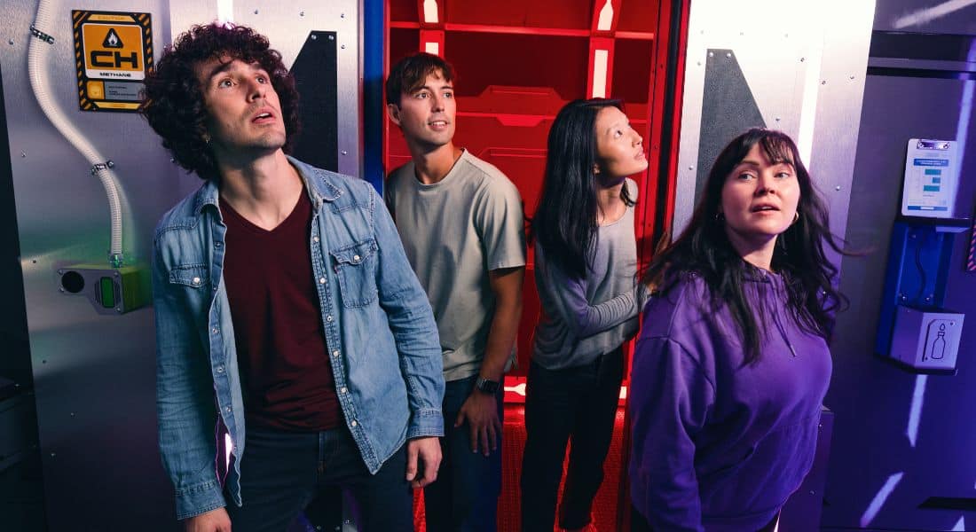 A team works on their galactic mission in Cosmic Crisis, facing The Escape Game's sci-fi challenges together.