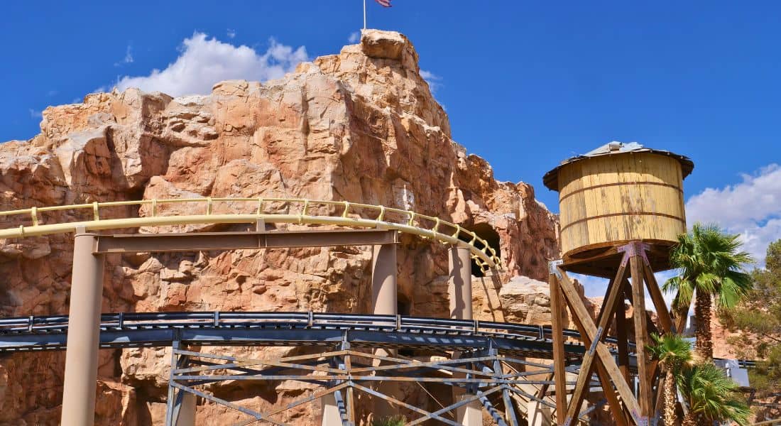 In this image you can see black train tracks going under the roller coaster tracks and over the log flume. (photo by Joe Tracy for Theme Park Magazine)
