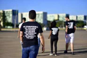 Man wearing t-shirt with "no homophobia, no violence" and other positive phrases - 10 Mindful Living Tips Inspired by the Dalai Lama