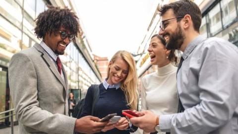 Photo of 4 agents on cell phones in a group