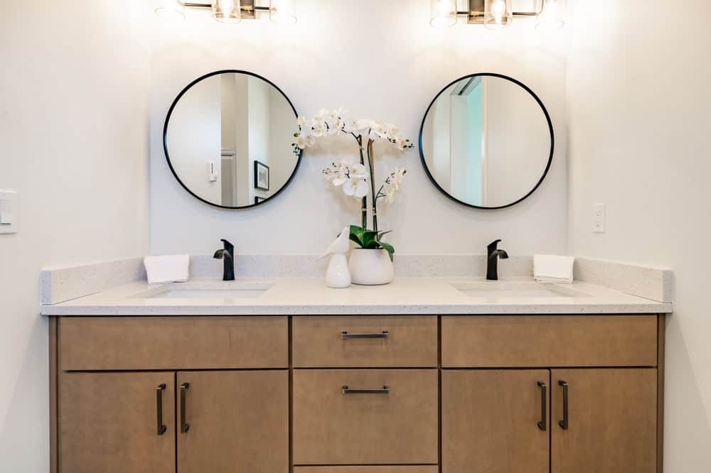 Primary,Bathroom,With,Brown,Wood,Cabinets,Round,Mirrors,Glass,Wall