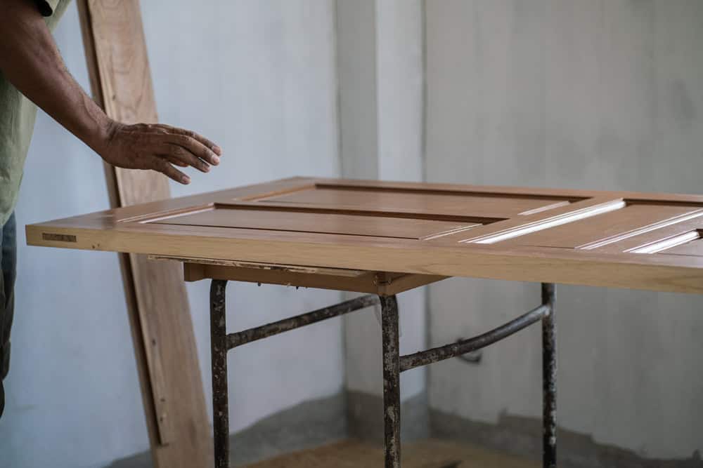 Carpenter,Man,Working,With,Teak,Wooden,Door,Installation,In,New