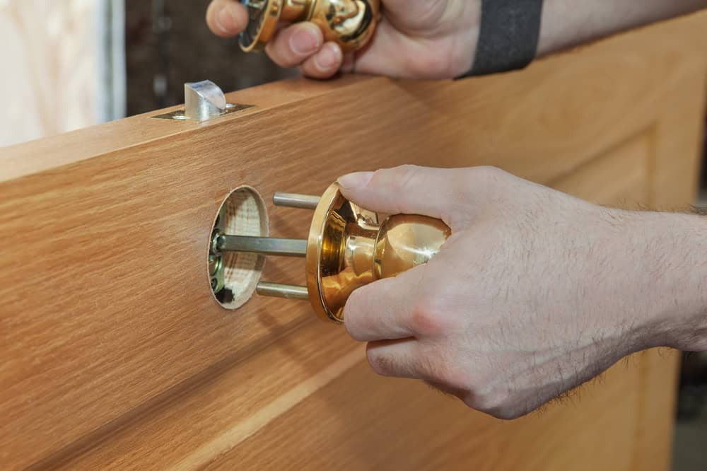 Installing,New,Interior,Door,,Close up,Carpenter,Hand,Holding,Spherical,Shaped