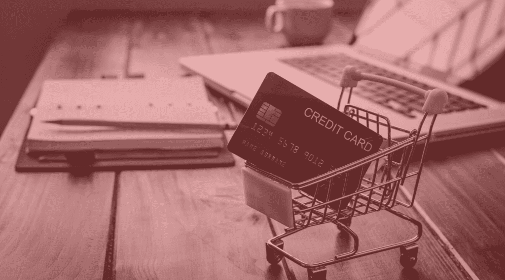 Tiny shopping cart holds credit card to show concept of CBD merchant payment processing solutions