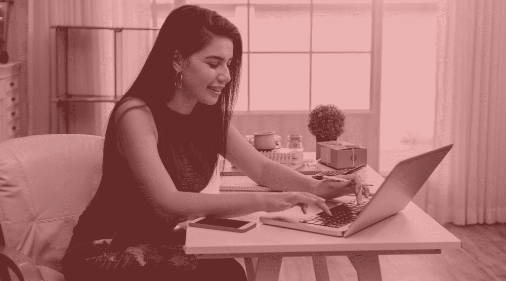 woman sits at desk with laptop and makes online purchases for Black Friday and Cyber Monday