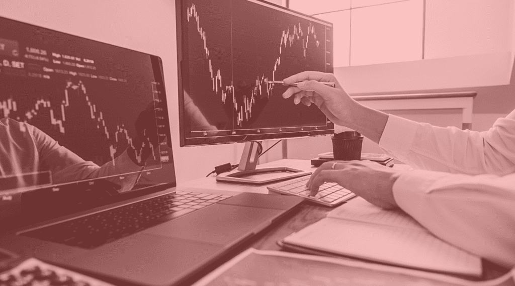 Hand points to stock market charts on computer screen to show concept of increased sales with the right CBD merchant payment processor