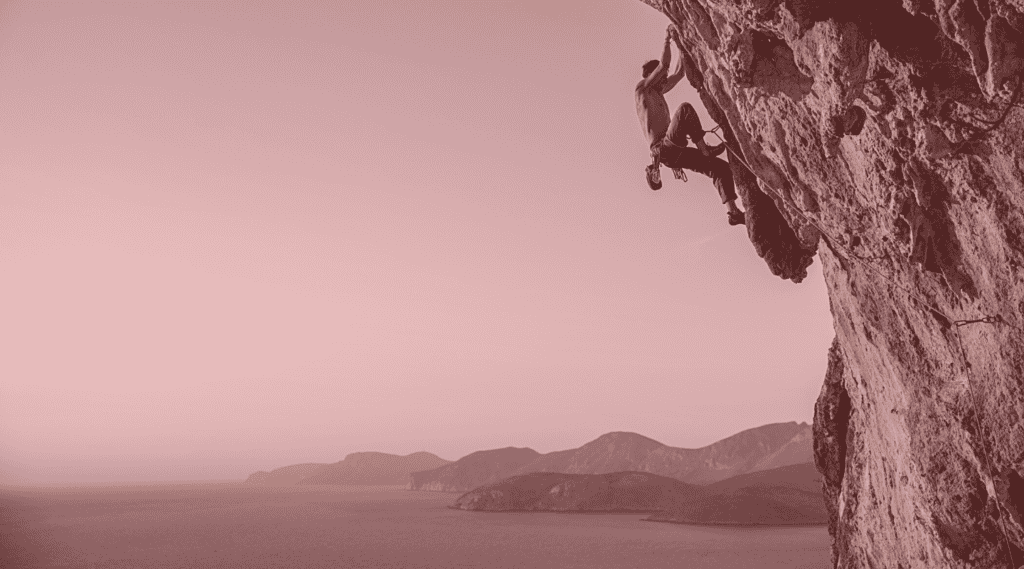 Man climbing cliffside to depict concept of high-risk merchant