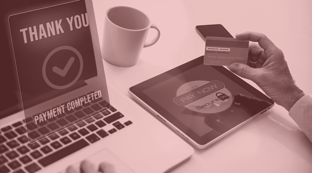 Laptop, coffee, credit card. Online purchase being made.