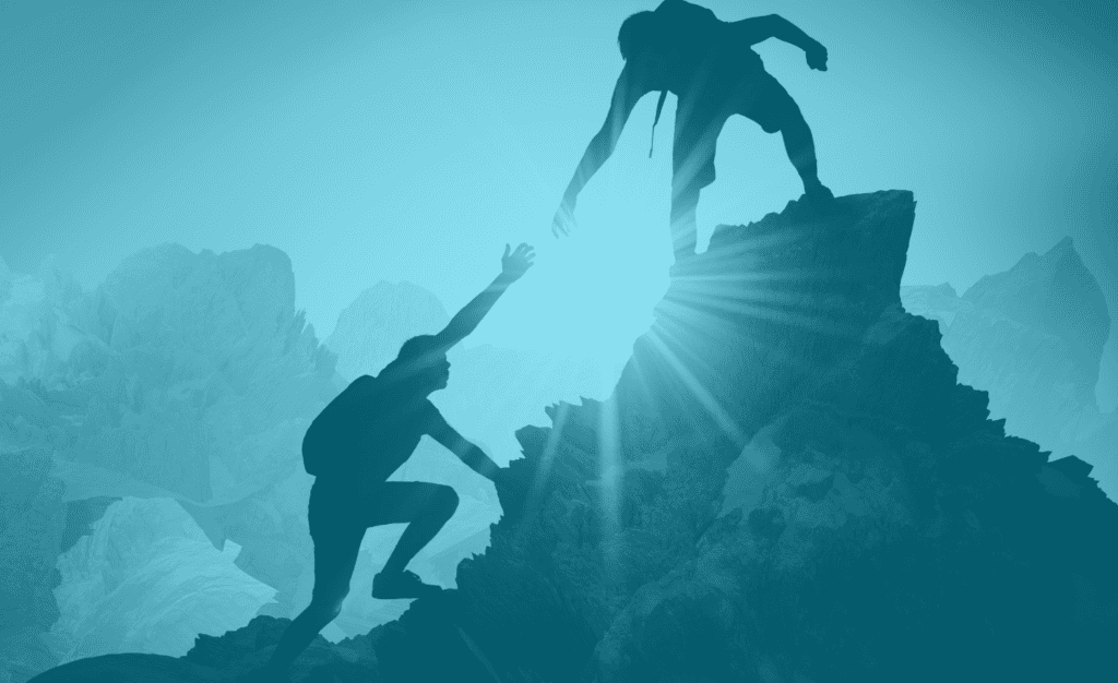 One man holding out hand to help second man get to top of a mountain to represent concept of customer service.