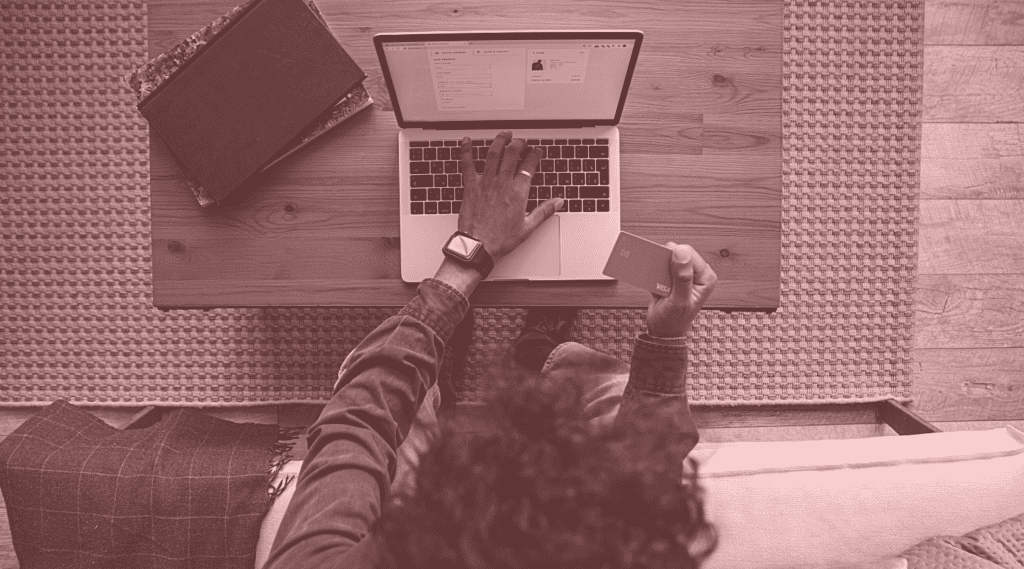 Overhead view of person sitting in front of a laptop and typing in a credit card number