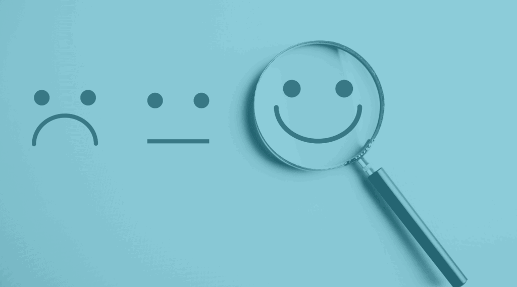 Emojis to show customer service satisfaction with a magnifying glass on the happy face emoji.