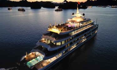 Luxurious yacht cruise at sunset in Ha Long Bay, Vietnam, offering elegant dining and sightseeing experiences.
