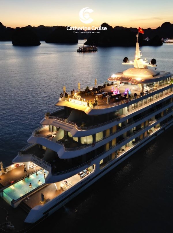 Luxurious yacht cruise at sunset in Ha Long Bay, Vietnam, offering elegant dining and sightseeing experiences.