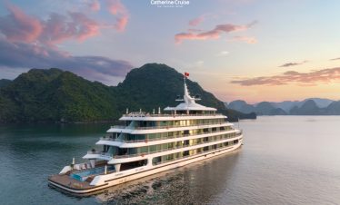 Luxury cruise ship sailing in Ha Long Bay at sunset, scenic limestone islands, Vietnam tourism.